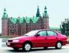 Bil. Toyota Carina E, bygget p Toyotas fabrik i England, var den mest solgte bil i Danmark i 1994. Med tvrstillet motor og forhjulstrk samt anonyme afrundede karosseriformer er den helt i overensstemmelse med tidens norm.